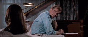 Movie still from “Cape Fear” (1991), directed by Martin Scorsese – An older man sitting on a bed looking at a laptop; Medium shot, Over the shoulder angle