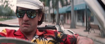 Movie still from “Cape Fear” (1991), directed by Martin Scorsese – A man wearing a hawaiian shirt and a hat driving a motorcycle; Close Up shot, Low angle