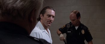 Movie still from “Cape Fear” (1991), directed by Martin Scorsese – A person with a microphone in a room; Close Up shot, Over the shoulder angle
