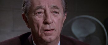Movie still from “Cape Fear” (1991), directed by Martin Scorsese – An older man in a suit and tie looking at the camera; Close Up shot, High angle
