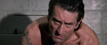 Movie still from “Cape Fear” (1991), directed by Martin Scorsese – A man with a tattoo on his arm is looking at the camera; Close Up shot, Low angle