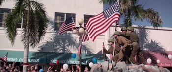 Movie still from “Cape Fear” (1991), directed by Martin Scorsese – A group of men in military garb holding american flags; Wide shot, High angle