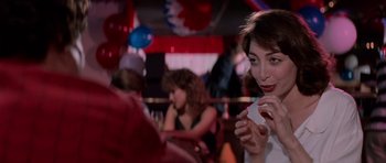 Movie still from “Cape Fear” (1991), directed by Martin Scorsese – A woman sitting at a table in front of other people; Close Up shot, Over the shoulder angle