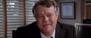 Movie still from “Cape Fear” (1991), directed by Martin Scorsese – A man in a suit and tie smiling for the camera; Close Up shot, Low angle