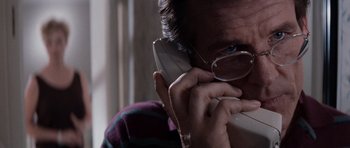 Movie still from “Cape Fear” (1991), directed by Martin Scorsese – A man with glasses is talking on a phone; Close Up shot, Low angle