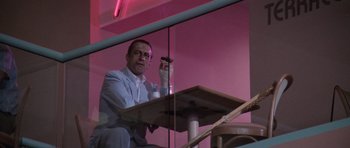 Movie still from “Cape Fear” (1991), directed by Martin Scorsese – A man sitting at a table holding a cell phone; Medium shot, Low angle