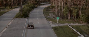 Movie still from “Cape Fear” (1991), directed by Martin Scorsese – A car driving down a road near some trees; Extreme Wide shot, High angle