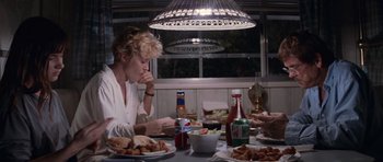 Movie still from “Cape Fear” (1991), directed by Martin Scorsese – A woman sitting at a dinner table eating food; Medium shot, High angle