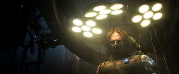 Movie still from “Captain America: Civil War” (2016), directed by Anthony Russo – A person with a mask on standing in front of an operating room light; Medium shot, Low angle