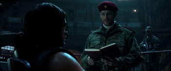 Movie still from “Captain America: Civil War” (2016), directed by Anthony Russo – A man in a military uniform is reading a book; Close Up shot, Over the shoulder angle