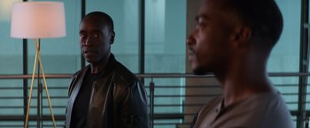 Movie still from “Captain America: Civil War” (2016), directed by Anthony Russo – Two black men are standing next to a railing; Close Up shot, Over the shoulder angle
