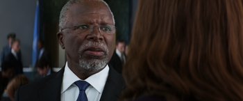 Movie still from “Captain America: Civil War” (2016), directed by Anthony Russo – An older man wearing a suit and tie talking to a woman; Close Up shot, Over the shoulder angle