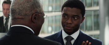 Movie still from “Captain America: Civil War” (2016), directed by Anthony Russo – A man in a suit and tie talking to another man; Close Up shot, Over the shoulder angle