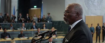 Movie still from “Captain America: Civil War” (2016), directed by Anthony Russo – An older man speaking at a podium in front of an audience; Close Up shot, Over the shoulder angle