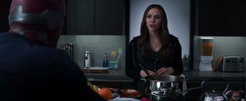 Movie still from “Captain America: Civil War” (2016), directed by Anthony Russo – A woman in a black shirt is in a kitchen; Medium shot, Over the shoulder angle