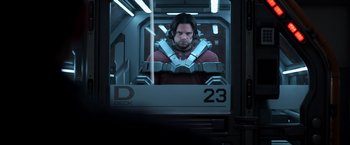 Movie still from “Captain America: Civil War” (2016), directed by Anthony Russo – A man in a red shirt is looking out of a window; Medium shot, Over the shoulder angle