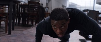 Movie still from “Captain America: Civil War” (2016), directed by Anthony Russo – A young man doing push - ups in a room; Close Up shot, High angle