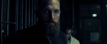 Movie still from “Captain America: Civil War” (2016), directed by Anthony Russo – A man with a beard and a goatee is looking at the camera; Close Up shot, Low angle