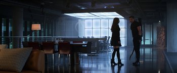 Movie still from “Captain America: Civil War” (2016), directed by Anthony Russo – A woman in a black dress walking in a room; Wide shot, Over the shoulder angle