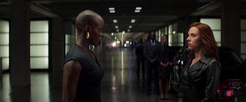 Movie still from “Captain America: Civil War” (2016), directed by Anthony Russo – A woman standing in a hallway with other people; Medium shot, Over the shoulder angle