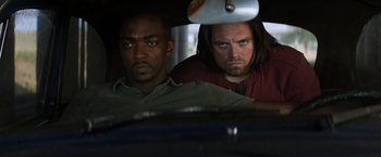 Movie still from “Captain America: Civil War” (2016), directed by Anthony Russo – Two men are sitting in a car looking at the camera; Medium shot, Over the shoulder angle