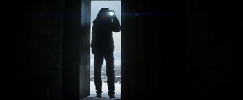 Movie still from “Captain America: Civil War” (2016), directed by Anthony Russo – A man standing in a doorway looking through a telescope; Wide shot, Low angle