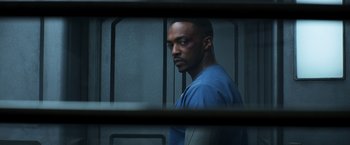 Movie still from “Captain America: Civil War” (2016), directed by Anthony Russo – A man in a blue shirt is behind bars; Close Up shot, Over the shoulder angle