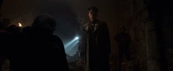 Movie still from “Captain America: The First Avenger” (2011), directed by Joe Johnston – A man in a military uniform standing next to a wall; Medium shot, Low angle