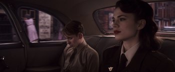 Movie still from “Captain America: The First Avenger” (2011), directed by Joe Johnston – A man and a woman sitting in the back of a car; Medium shot, Over the shoulder angle
