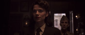 Movie still from “Captain America: The First Avenger” (2011), directed by Joe Johnston – A woman in a military uniform is looking at the camera; Close Up shot, Over the shoulder angle