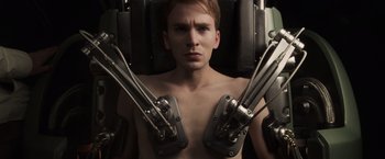 Movie still from “Captain America: The First Avenger” (2011), directed by Joe Johnston – A shirtless man in a chair with metal arms; Close Up shot, Low angle