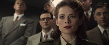 Movie still from “Captain America: The First Avenger” (2011), directed by Joe Johnston – A woman in a military uniform and a man in a suit and tie; Close Up shot, Over the shoulder angle
