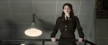 Movie still from “Captain America: The First Avenger” (2011), directed by Joe Johnston – A woman dressed in a uniform standing next to a railing; Medium shot, Low angle
