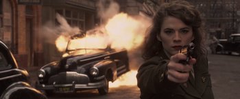 Movie still from “Captain America: The First Avenger” (2011), directed by Joe Johnston – A woman pointing at a car on fire; Close Up shot, Over the shoulder angle