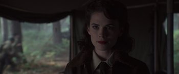 Movie still from “Captain America: The First Avenger” (2011), directed by Joe Johnston – A woman in a brown jacket is looking at the camera; Close Up shot, Over the shoulder angle