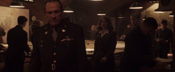 Movie still from “Captain America: The First Avenger” (2011), directed by Joe Johnston – A man and a woman standing next to each other in a room; Medium shot, Over the shoulder angle