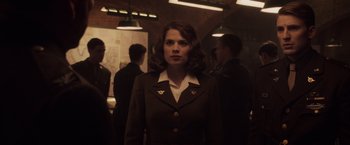 Movie still from “Captain America: The First Avenger” (2011), directed by Joe Johnston – A woman in a uniform standing in front of a group of people; Medium shot, Over the shoulder angle