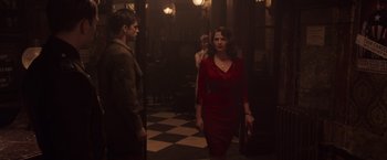 Movie still from “Captain America: The First Avenger” (2011), directed by Joe Johnston – A woman in a red dress walking down a hall way; Medium shot, Over the shoulder angle
