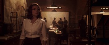 Movie still from “Captain America: The First Avenger” (2011), directed by Joe Johnston – A woman standing in front of a group of people; Medium shot, Over the shoulder angle