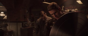 Movie still from “Captain America: The First Avenger” (2011), directed by Joe Johnston – A man in a military uniform is holding a guitar; Close Up shot, Low angle
