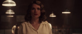 Movie still from “Captain America: The First Avenger” (2011), directed by Joe Johnston – A woman in a white shirt is standing in a dimly - lit room; Close Up shot, Over the shoulder angle