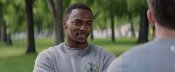 Movie still from “Captain America: The Winter Soldier” (2014), directed by Anthony Russo – A person sitting in the grass; Close Up shot, Over the shoulder angle