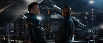 Movie still from “Captain America: The Winter Soldier” (2014), directed by Anthony Russo – Two men are standing next to each other in front of a telescope; Medium shot, Over the shoulder angle