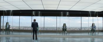 Movie still from “Captain America: The Winter Soldier” (2014), directed by Anthony Russo – A man standing in front of a window looking out at a city; Wide shot, Over the shoulder angle