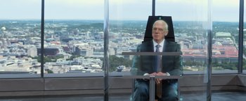 Movie still from “Captain America: The Winter Soldier” (2014), directed by Anthony Russo – An older man sitting in a chair in front of a window; Medium shot, Over the shoulder angle