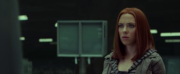 Movie still from “Captain America: The Winter Soldier” (2014), directed by Anthony Russo – A woman with red hair standing in front of a television; Close Up shot, Low angle