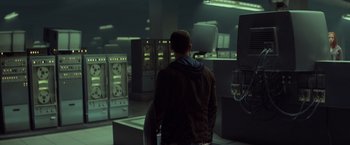 Movie still from “Captain America: The Winter Soldier” (2014), directed by Anthony Russo – A man standing in front of computer equipment; Wide shot, Low angle