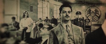 Movie still from “Captain America: The Winter Soldier” (2014), directed by Anthony Russo – A man in a suit and tie in front of a group of people; Medium shot, Low angle