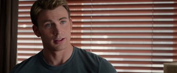 Movie still from “Captain America: The Winter Soldier” (2014), directed by Anthony Russo – A person wearing a green shirt near a window; Close Up shot, Over the shoulder angle