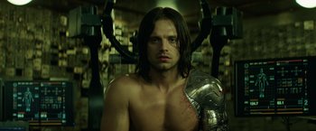 Movie still from “Captain America: The Winter Soldier” (2014), directed by Anthony Russo – A man with long dark hair holding a metal helmet; Close Up shot, Low angle